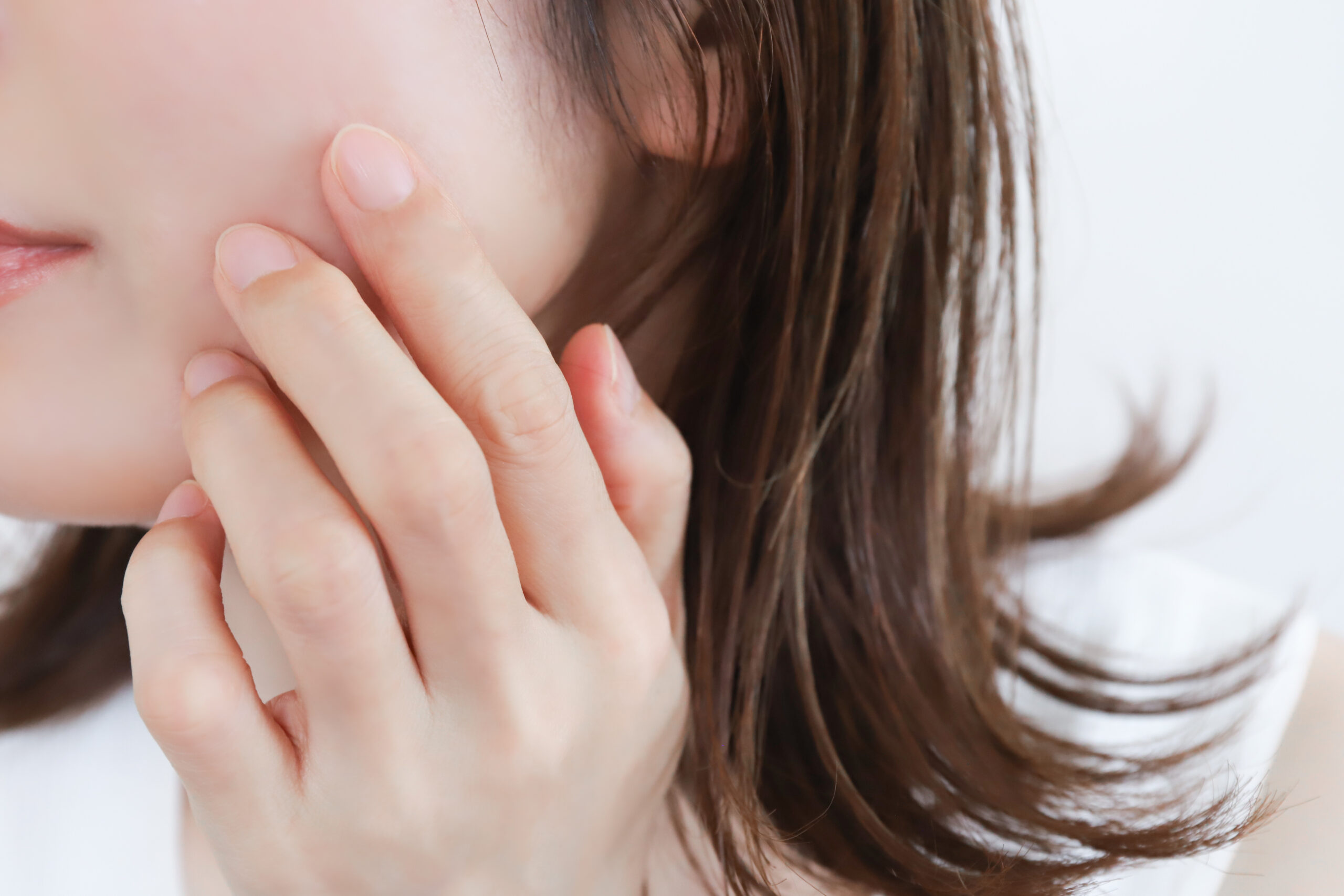 顔に手を添える女性のアップ